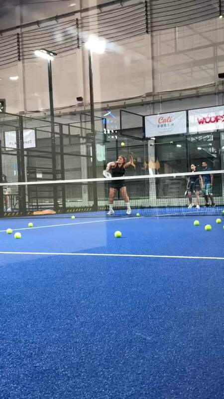Player mid-swing on an overhead at Baan Padel